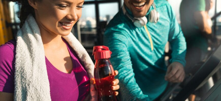 A man and a woman running on side by side treadmills